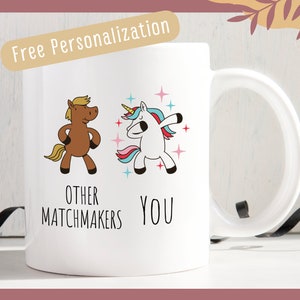 May include: White ceramic mug with a brown horse and a blue and pink unicorn illustration. The text reads "Other Matchmakers" and "You".