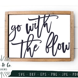 May include: A white wooden sign with a black inscription that reads "go with the flow".
