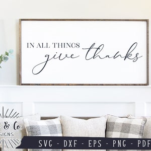 May include: A white wooden sign with a brown frame, featuring the text "IN ALL THINGS give thanks" in black cursive font.