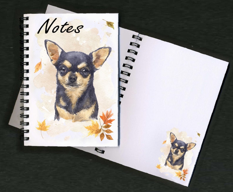 May include: A spiral bound notebook with a watercolor illustration of a black and tan chihuahua with autumn leaves. The cover says "Notes".