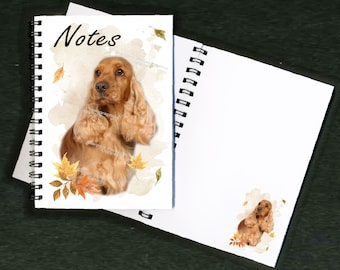 May include: A spiral bound notebook with a watercolor illustration of a golden cocker spaniel dog with autumn leaves. The front cover says "Notes".
