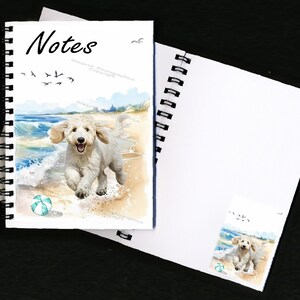 May include: A spiral bound notebook with a watercolor illustration of a white dog running on a beach with a blue and green beach ball. The cover says "Notes" and has a copyright notice.