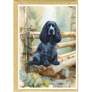 May include: A greeting card featuring a blue roan Cocker Spaniel sitting on a rustic wooden bench. The dog has long, wavy fur and a white patch on its face. The background includes a wooden fence and foliage, creating a serene outdoor scene.
