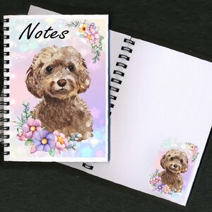 May include: A spiral bound notebook with a watercolor illustration of a brown poodle with pink and purple flowers on a pink and blue background. The front cover says "Notes".