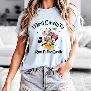 May include: Light blue t-shirt featuring a graphic of Disney characters including Mickey Mouse, Minnie Mouse, Donald Duck, Daisy Duck, Goofy, and Pluto. The text "Most Likely To Run to the Castle" is printed above the characters.