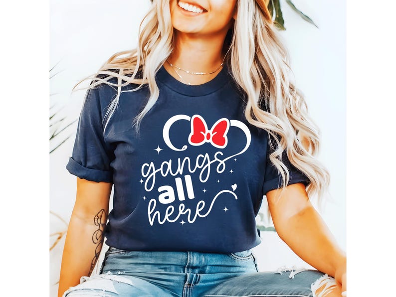 K&ouml;nnte beinhalten: Marineblaues T-Shirt mit dem wei&szlig;en Schriftzug "gangs all here". Das Design beinhaltet eine rote Schleife und wei&szlig;e Mickey Mouse Ohren. Ein l&auml;ssiges T-Shirt.