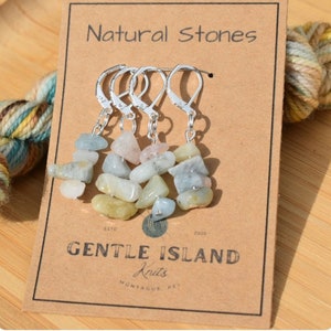 May include: Four silver stitch markers with natural stone charms. Each charm is a stack of small, light blue, green, and pink stones. The card reads "Natural Stones" and "Gentle Island Knits".