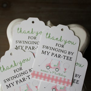 May include: Four white thank you tags with green and black text. The tags feature a golf cart and golf balls with a pink and white gingham pattern. The text on the tags reads "Thank you for swinging by my par-tee".