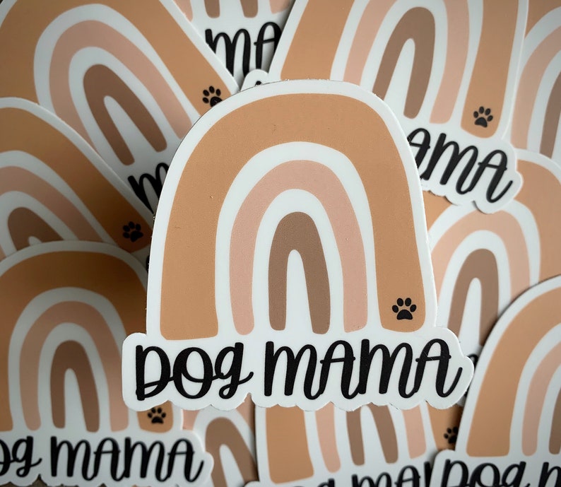 May include: A set of rainbow-colored stickers with the text "Dog Mama" in black lettering. The stickers feature a paw print design.