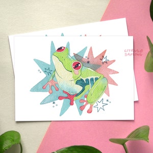 May include: A watercolor illustration of a green tree frog with red eyes, sitting on a blue and pink starburst background. The text "CITRUS SAPLING" is written in the top right corner.