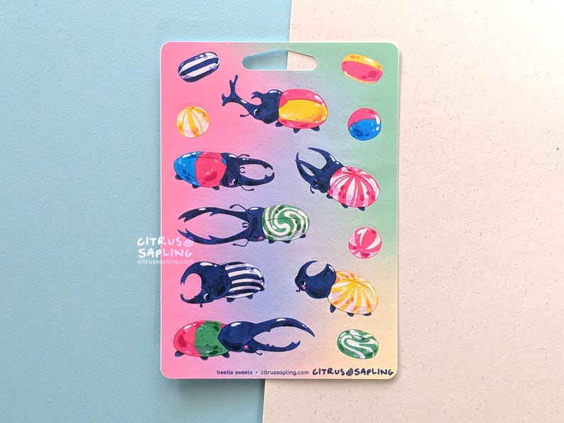 May include: A sticker sheet featuring colorful illustrations of beetles and candies. The beetles are depicted with various patterns and colors, such as red, yellow, blue, and green. The candies are round and striped. The text "beetle sweets" is visible.