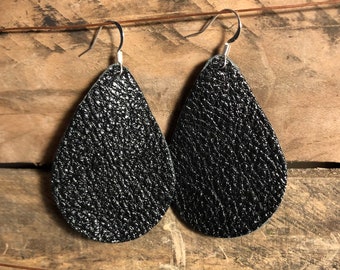 May include: A pair of black leather teardrop earrings with silver hooks.