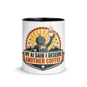Puede incluir: Una taza de cerámica blanca con interior y borde negros, que presenta un gráfico de un robot azul sosteniendo una taza de café. El diseño incluye un sol amarillo, montañas y el texto "MY AI SAID I DESERVE ANOTHER COFFEE." en azul y naranja.