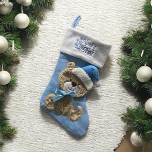 Può includere: Calza di Natale blu e bianca con un'applicazione di orsacchiotto e il testo "Noah's 1st Christmas 2023".