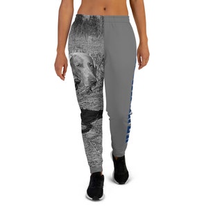 Peut inclure: Pantalon de survêtement gris avec une photo en noir et blanc d'un chien sur une jambe et du texte bleu sur l'autre jambe.