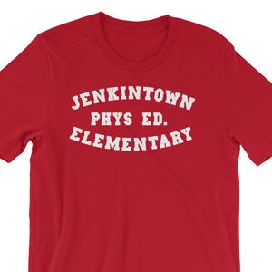 May include: Red short-sleeved t-shirt with white text that reads "Jenkintown Phys Ed. Elementary"