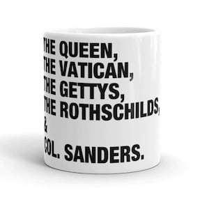May include: White ceramic coffee mug with black text that reads "THE QUEEN, THE VATICAN, THE GETTYS, THE ROTHSCHILDS & COL. SANDERS."
