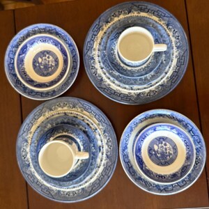May include: A collection of blue and white ceramic dishes, including plates, bowls, and cups. The tableware features a classic, detailed pattern. The arrangement includes multiple place settings, ideal for a formal dining experience.
