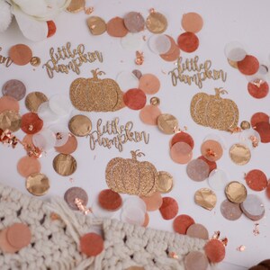 May include: Gold glitter confetti with the text "little pumpkin" and a gold glitter pumpkin image. The confetti is on a white background with peach, brown, and gold confetti.