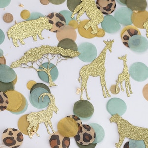 May include: Safari-themed confetti with gold glitter animal cutouts, including giraffes, lions, and elephants, scattered among green, brown, and leopard print circles. Gold leaf accents add a touch of sparkle to this decorative party supply.