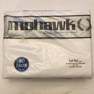 May include: A packaged white full flat sheet by Mohawk. The packaging includes the brand name, product details, and the text "No Iron Stays Neat". The sheet measures 81 x 104 inches and is made of 50% cotton and 50% polyester.