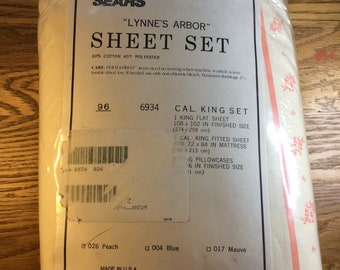 May include: A packaged Sears "Lynne's Arbor" Cal. King sheet set. The packaging is cream-colored with peach and white floral accents. The label indicates the set includes a flat sheet (108 x 102 inches), a fitted sheet, and two pillowcases.