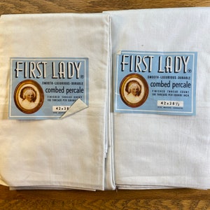 May include: Two white combed percale sheets with labels that read "FIRST LADY". The labels have a portrait in a gold frame and state the thread count is 186 per square inch. The sheets measure 42 x 38 inches before hemming.