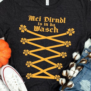 Funny Oktoberfest Dirndl Costume Shirt – "Mei Dirndl is in da Wäsch" Alpine Bavarian Lace-Up look Tee for German Beer Festival