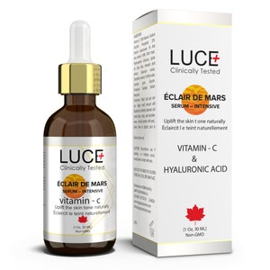 May include: A brown glass bottle with a gold cap and label. The label reads "LUCE+ Clinically Tested ÉCLAIR DE MARS SERUM - INTENSIVE vitamin - c Uplift the skin tone naturally Éclaircit le teint naturellement [1 Oz, 30 ML] Non-GMO". The bottle is next to a white box with a similar label. The box reads "LUCE+ Clinically Tested ÉCLAIR DE MARS SERUM - INTENSIVE Uplift the skin tone naturally Éclaircit le teint naturellement VITAMIN - C & HYALURONIC ACID [1 Oz, 30 ML] Non-GMO".