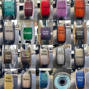 Puede incluir: Una cuadr&iacute;cula de bobinas de filamento de impresi&oacute;n 3D en varios colores, incluyendo verde azulado, rojo, lavanda, naranja, blanco, verde, morado/negro, naranja quemado, oro/negro, seda arco&iacute;ris, seda blanca, plata/gris claro, cristal, amarillo p&aacute;lido, hueso, azul/verde, transici&oacute;n de invierno y azul real.