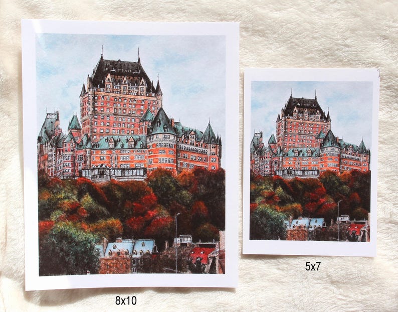May include: Two art prints of a grand, red-brick castle with multiple turrets and a dark roof, set against a light blue sky. The castle sits atop a hill with colorful autumn foliage. One print is 8x10 inches, the other is 5x7 inches.