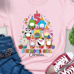 Puede incluir: Camiseta rosa con un gráfico de un pastel de cumpleaños con animales y el número 5. El texto "Birthday Girl Christine" está debajo del pastel.