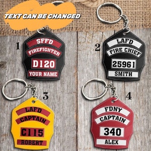 May include: Four different firefighter keychain designs. The keychains are made of leather and feature different department names, badges, and numbers. The keychains are black, red, yellow, and white.