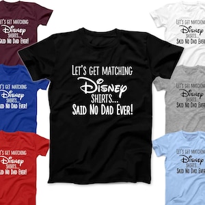 May include: A set of seven t-shirts in different colors, each featuring the text "Let's get matching Disney shirts... Said no dad ever!" in white lettering.