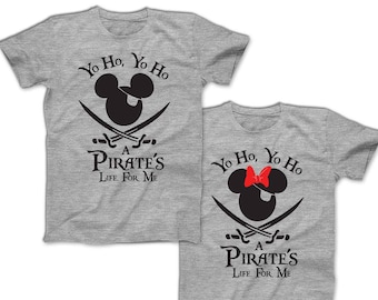 May include: Two gray t-shirts with a black and white Mickey Mouse pirate design. The text on the shirts reads "Yo Ho, Yo Ho A Pirate's Life For Me".