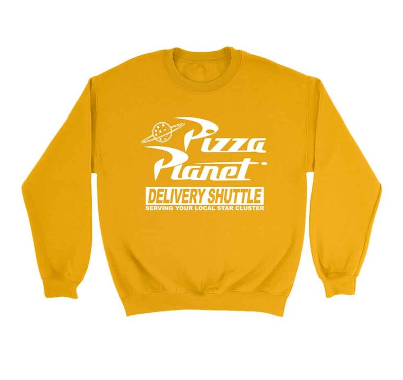 Pu&ograve; includere: Felpa gialla con una grafica bianca di un logo di Pizza Planet con il testo "Pizza Planet Delivery Shuttle Serving Your Local Star Cluster".