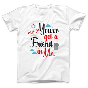 May include: White t-shirt with a cartoon image of a toy character with a red ribbon and a trash can. The text "You've got a Friend in Me" is printed in black and red.