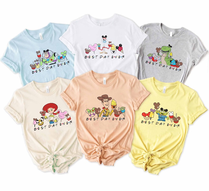 May include: Six different t-shirts with a variety of Disney characters and the text "BEST DAY EVER" printed on them. The shirts are in different colors, including light blue, white, gray, beige, peach, and yellow.