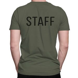 May include: A green short-sleeved t-shirt with the word "STAFF" printed in black on the back.