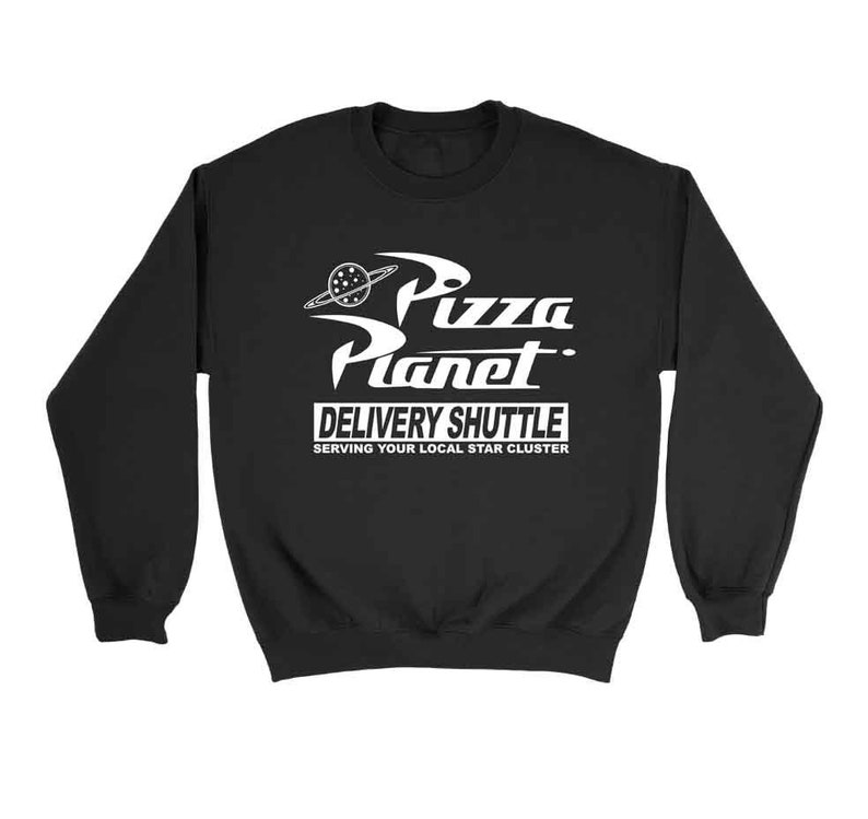 Pu&ograve; includere: Felpa nera con una grafica bianca di un logo di Pizza Planet. Il logo presenta un pianeta con una fetta di pizza e il testo "Pizza Planet Delivery Shuttle Serving Your Local Star Cluster".