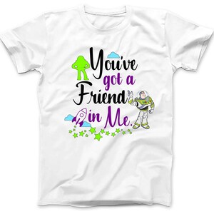 May include: White t-shirt with a green alien and a cartoon of Buzz Lightyear from Toy Story. The text on the shirt reads "You've got a friend in me."