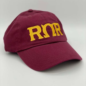 May include: A maroon baseball cap with a gold embroidered "ROR" logo.