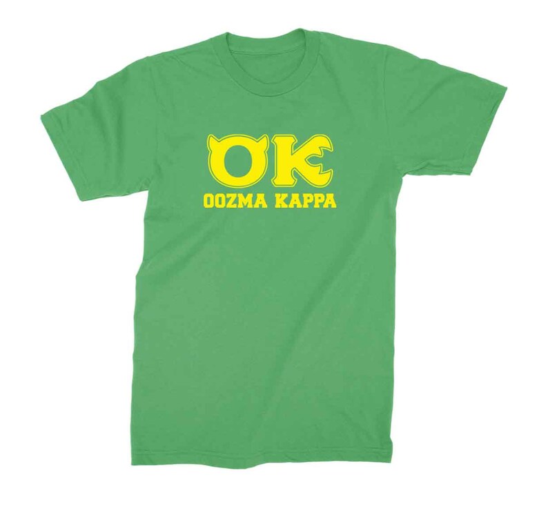 Peut inclure: Un t-shirt vert avec un logo "OK" jaune et le texte "OOZMA KAPPA" imprim&eacute; sur le devant.