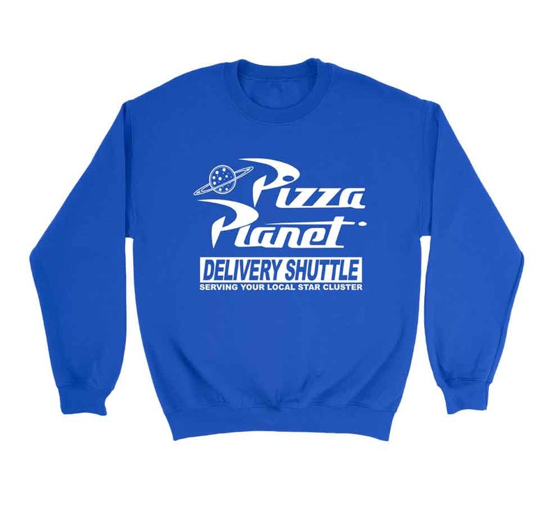 Pu&ograve; includere: Una felpa blu reale con una grafica bianca del logo Pizza Planet del film Toy Story. Il logo presenta un pianeta con un anello e il testo "Pizza Planet Delivery Shuttle Serving Your Local Star Cluster".