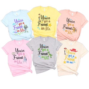May include: Six different t-shirts with a Toy Story theme. Each shirt features a different character from the movie, including Woody, Buzz Lightyear, Rex, and Jessie. The shirts are all light-colored and have the text "You've got a friend in me." printed on them.