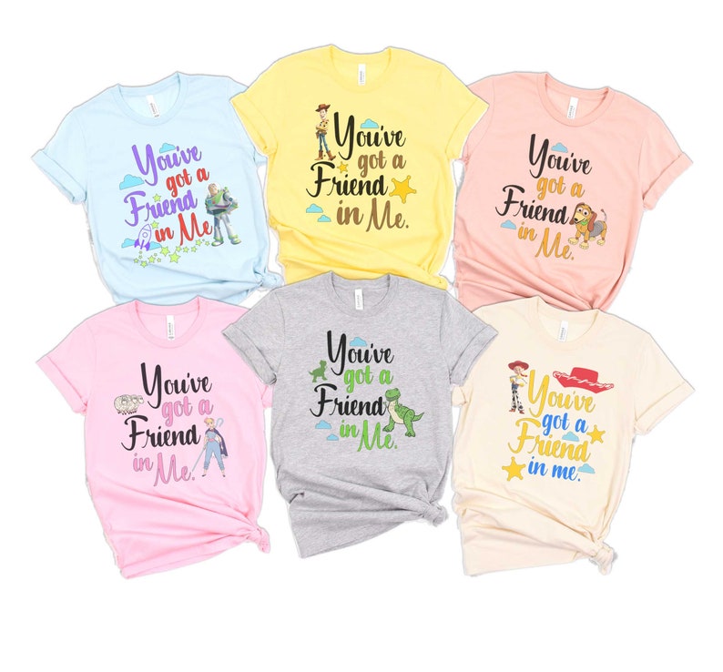 May include: Six different t-shirts with a Toy Story theme. Each shirt features a different character from the movie, including Woody, Buzz Lightyear, Rex, and Jessie. The shirts are all light-colored and have the text "You've got a friend in me." printed on them.