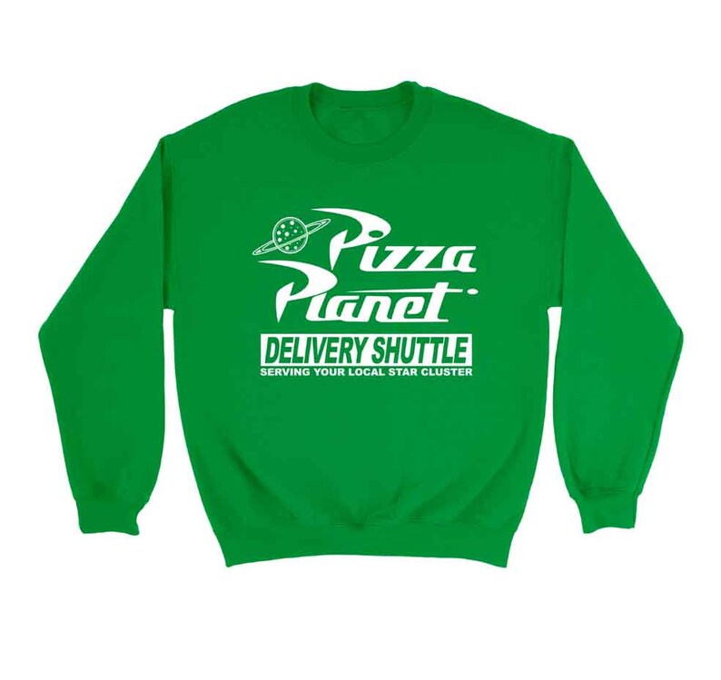 Pu&ograve; includere: Felpa verde con una grafica bianca del logo Pizza Planet del film Toy Story. Il logo dice "Pizza Planet Delivery Shuttle Serving Your Local Star Cluster".