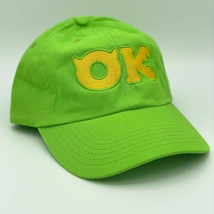 May include: A lime green baseball cap with a yellow embroidered "OK" logo.