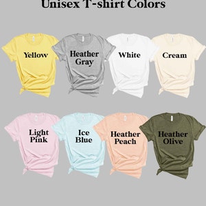 May include: A selection of unisex t-shirts in various colors, including yellow, heather gray, white, cream, light pink, ice blue, heather peach, and heather olive. The shirts are laid out flat on a gray background.