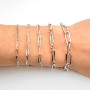 Peut inclure: Un ensemble de cinq bracelets en chaîne argentés de différentes longueurs et tailles de maillons.